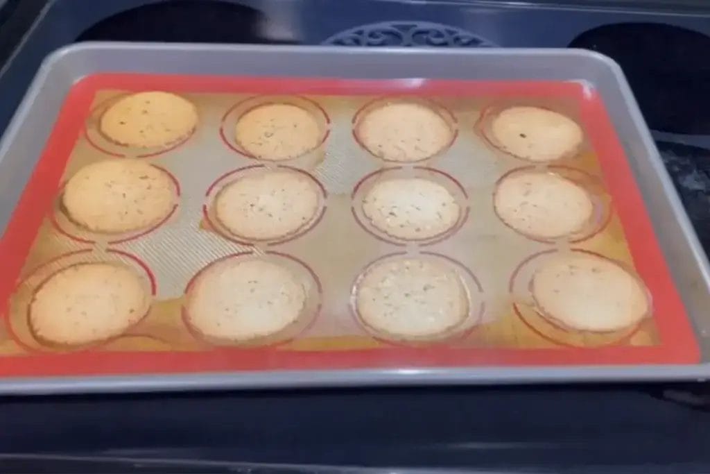 Freshly baked cottage cheese chips cooling on a baking sheet with a silicone mat