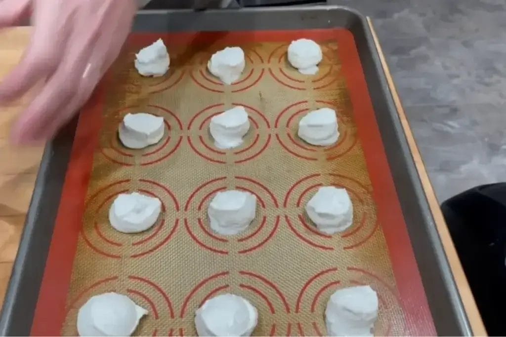  Scoops of cottage cheese placed on a silicone baking mat, ready to be baked into crispy chips.